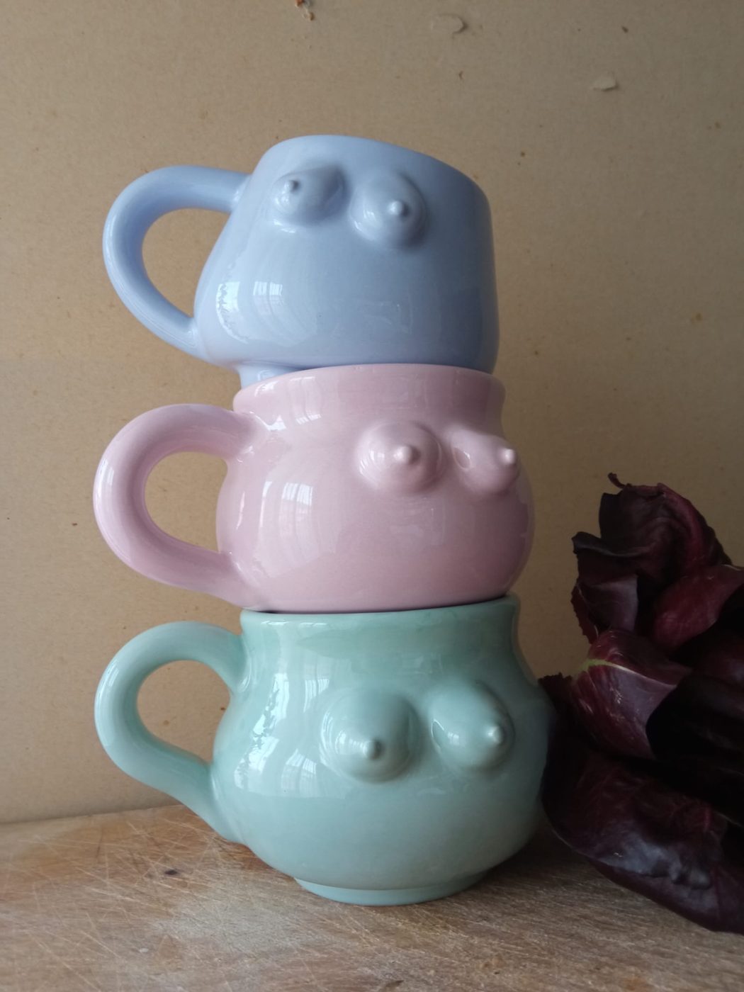 Tre tettazze impilate: tazze scultura in ceramica smaltata azzurra, rosa e verde